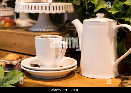 Gros plan sur une table en bois, avec teapot en porcelaine et teapot à la fausse décoration végétale. Banque D'Images