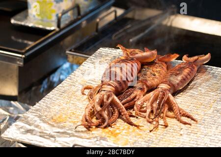 Calmars frais cuits sur une poêle. Cuisine de rue saumone sauté coréenne à Myeongdong, Corée du Sud. Banque D'Images