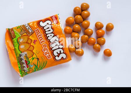 Paquet de mini œufs orange Nestle Smarties ouverts avec le contenu renversé isolé sur fond blanc - prêt pour Pâques Banque D'Images