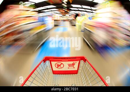 Panier vide dans le supermarché, arrière-plan flou Banque D'Images