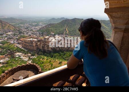 Vue arrière d'une fille regardant vers Amer fort (ou fort Amber) du fort Jaigarh à Jaipur, Inde Banque D'Images