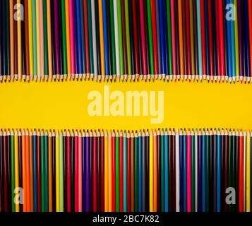 Crayons de couleur sur fond jaune. Papier à lettres avec photo en hauteur sur papier Banque D'Images