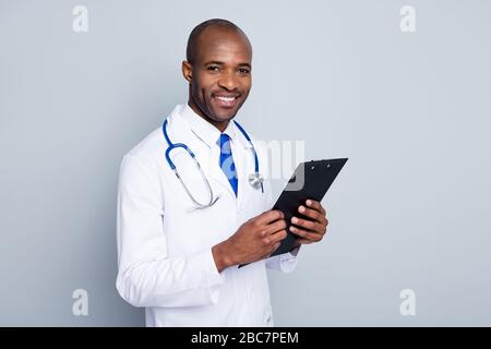 Photo du médecin de famille peau sombre gars joyeux beaming sourire patient tenir presse-papiers lire les résultats de test de prescription porter blouse de laboratoire cou cravate stéthoscope Banque D'Images