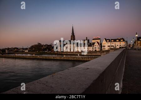 La rivière Maas / Meuse dans le centre de Maastricht avec vue sur la brasserie de bière Ridder pendant le coucher du soleil avec un ciel incroyable plein de couleur. Banque D'Images