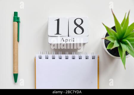 Date sur des cubes de bois blancs - le 18, 18 avril sur une table blanche. Vue de dessus. Gros plan. Banque D'Images