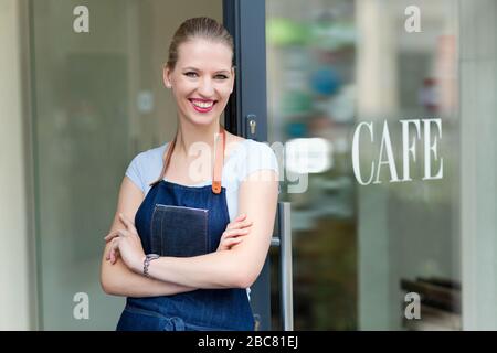 Fière jeune femme propriétaire de café Banque D'Images