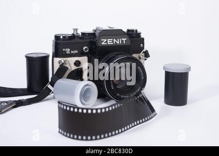 ancienne caméra de cinéma 35 mm et objectifs de caméra avec des contenants de film et des bandes de film autour isolés sur le fond blanc Banque D'Images