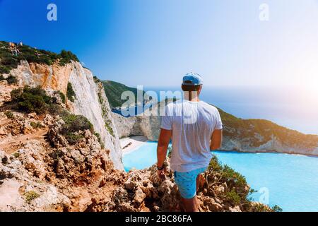 Les hommes de tourisme bénéficiant d'une vue spectaculaire des hauts-lieux à la plage Navagio sur l'île de Zakynthos. Banque D'Images