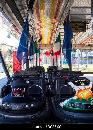 AULLA, ITALIE - 12 février 2020: Rangées de Dodgem aka Bumper Cars stationné dans le parc d'attractions Fun Fair. Avec drapeau italien. Banque D'Images