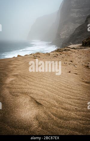 Santo Antao, Cap-Vert - Cruzinha Da Garca. Côte de Mountain moody et vagues de l'océan Atlantique. Dune de sable en premier plan. Banque D'Images