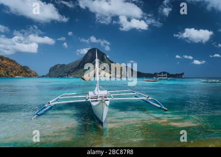 Panorama avec Cadlao filippino traditionnels banca bateau en avant. La baie de El Nido tropical exotique, l'île de Palawan, aux Philippines. Banque D'Images