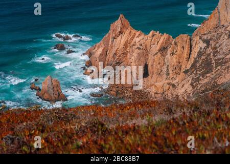 Praia do Ursa beach avec de belles falaises de couleur orange sur l'océan Atlantique près de la côte touristique populaire le phare du Cabo da Roca, au Portugal. Banque D'Images