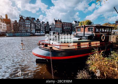 Péniche et bâtiments traditionnels s'appuyant le long du canal d'Amsterdam. Banque D'Images