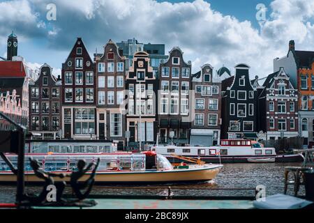 Canal d'Amsterdam Singel avec maisons et bateaux à la maison typiquement hollandais avec un beau paysage de nuages en arrière-plan, Hollande, Pays-Bas. Banque D'Images