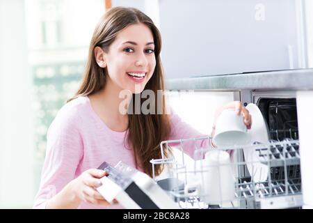 Femme loading lave-vaisselle Banque D'Images