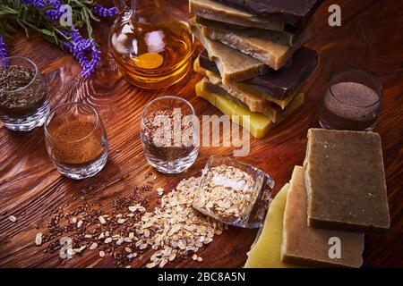 composition des ingrédients, de la lavande, de l'huile et du savon artisanal sur table en bois. Barres de savon faites à la main sur planche en bois. Banque D'Images