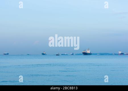Les navires de fret, les pétroliers et les vraquiers sont ancrés au large du Singapore Straight, à Singapour, au coucher du soleil Banque D'Images