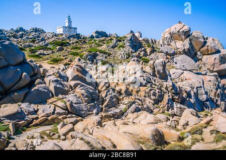 Phare blanc de Capo Testa au nord de la Sardaigne, Hudge Granite Rocks en face. Banque D'Images