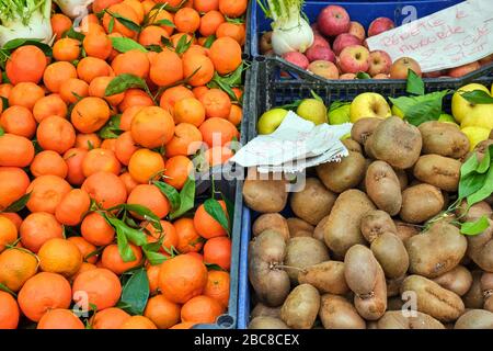 Tangerines, kiwis et pommes à vendre sur un marché Banque D'Images