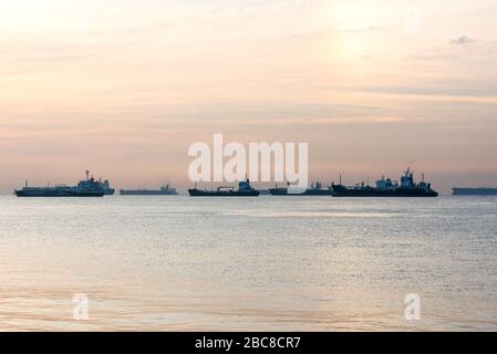 Les navires de fret, les pétroliers et les vraquiers sont ancrés au large du Singapore Straight, à Singapour, au coucher du soleil Banque D'Images
