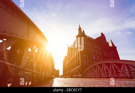 Silhouette de pont et bâtiments de rayons de soleil du soir en low angle view. Hamburg Speicherstadt. Célèbre monument de vieux bâtiments réalisés avec des briques rouges Banque D'Images