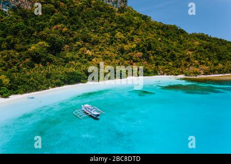 Vue aérienne de bateau amarré à la plage tropicale retirée avec sable blanc, lagon peu profond de l'océan turquoise et des cocotiers. Co exotiques voyage Banque D'Images