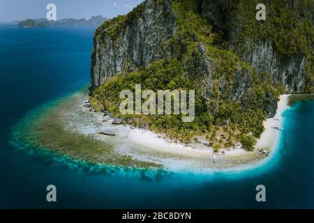 El Nido, Palawan, Philippines. Drone aérien de l'image surréaliste épique Pinagbuyutan Île avec plage lipi, bateaux et de palmiers à partir de ci-dessus. Banque D'Images