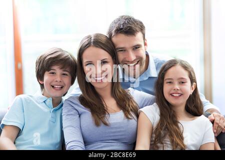 Jeune famille se détendre à la maison Banque D'Images