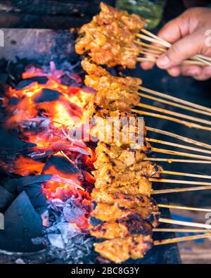 Gros plan vertical de satay, un plat traditionnel de Bali, en cours de cuisson. Banque D'Images