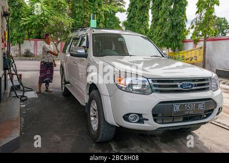 Vue horizontale d'un homme qui a fait le plein de sa voiture à Bali, en Indonésie. Banque D'Images