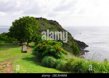 Vue sur le fort Rodney sur la pente rocheuse herbeuse surplombant l'immense océan au site national de Pigeon Island à Sainte-Lucie lors d'une belle journée ensoleillée Banque D'Images