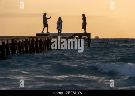 Espagne, Majorque, Playa de Muro, les touristes photographient le lever du soleil depuis une jetée de Playa de Muro, la plus longue plage de sable de Majorque Banque D'Images