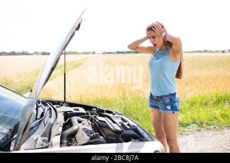 Femme avec une voiture en panne Banque D'Images