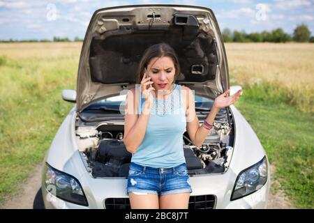 Femme avec une voiture en panne Banque D'Images