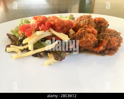 Vue de dessus de délicieux boulettes de viande avec sauce bolognaise et salade de laitue et bandes de mozzarella fromage. Délicieux repas de carb. Concept de délicieux et Banque D'Images