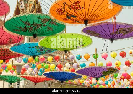 Parasols asiatiques colorés suspendus dans la rue de Bangkok en arrière-plan du toit du temple pendant la journée ensoleillée et chaude Banque D'Images