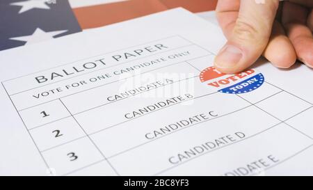 L'homme marque le candidat choisi avec l'autocollant Aujourd'hui que j'ai voté sur un bulletin de vote pour les élections présidentielles américaines. Banque D'Images