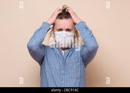 Fille dans le masque médical tenant les mains sur la tête, triste en raison de la maladie se sentant stressée en raison de la pandémie de covid 2019. Banque D'Images