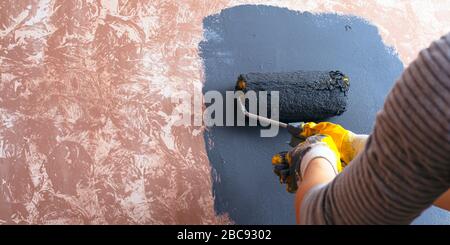 concept de réparation à domicile. une jeune fille peint une peinture murale. Banque D'Images