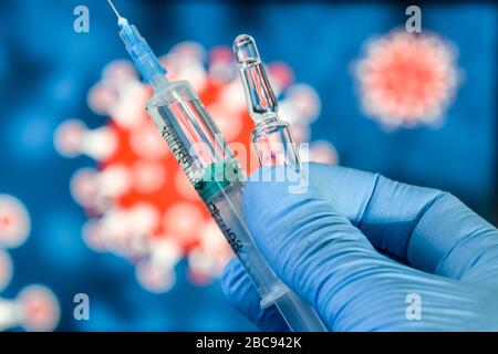 Vaccin contre le coronavirus. Une main dans des gants médicaux contient un vaccin et une seringue sur le fond de l'image d'un coronavirus. Covid-19, Banque D'Images