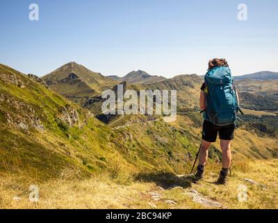 Trekking dans le Cantal sur le GR 400, montagnes volcaniques en France, chemin étroit sur le Puy Chavaroche. En arrière-plan Puy Mary sur la gauche et Puy Banque D'Images
