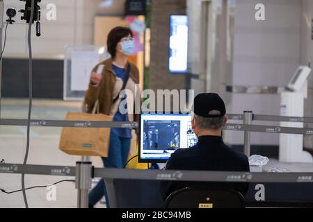 Un personnel de Taiwan High-Speed Rail (THSR) qui surveille la température corporelle d'un passager au milieu des craintes de Coronavirus.Taiwan a connu une augmentation de COVID-19 cas ces derniers jours, portant le nombre total à 348. Le gouvernement a publié de nouvelles règles de distanciation sociale et a rendu obligatoire le port de masques sur les transports publics. Banque D'Images