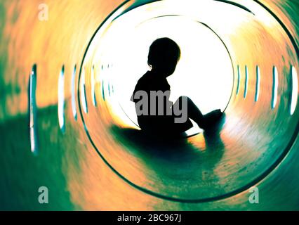 enfant en train de jouer à tube park silhouette Banque D'Images