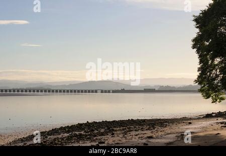 Northern Rail classe 142 paper train approchant Arnside viaduc peu après le lever du soleil en été avec les collines du district de lac derrière Banque D'Images