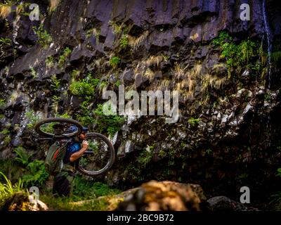 Mountain Biker porte son vélo à la Cascade de Faillitoux. Monts du Cantal, Massif Central, Cantal France Banque D'Images