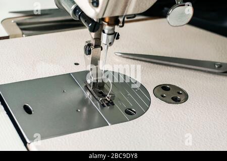 Aiguille et pied de machine à coudre se rapproche comme arrière-plan de fabrication Banque D'Images