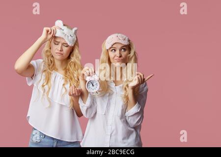 Deux jeunes femmes sans manches en pyjama et masques de sommeil sur fond rose. Réveil réveille les filles Banque D'Images