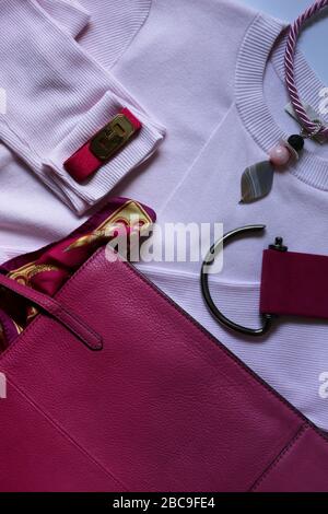 Épingler les accessoires pour femme sur un chiffon rose. Pose plate. Concept de fête, de célébration, de tenue élégante Banque D'Images