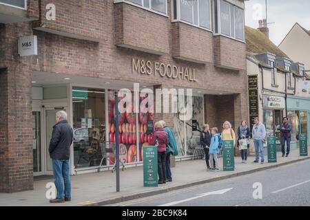 High Street, Reigate, Surrey, Royaume-Uni - 3 avril 2020 - les clients font la queue à l'extérieur du supermarché M&S, maintenant des distances sociales pour arrêter la propagation du coronovirus Banque D'Images