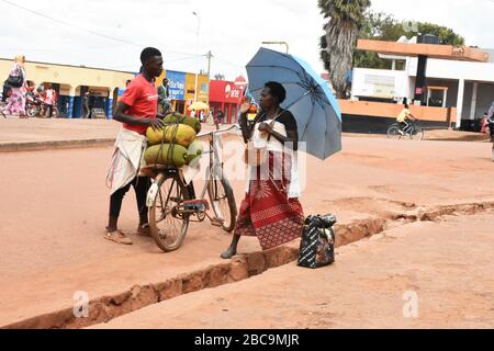 Un commerçant masculin et une femme négocient les prix des gros fruits dans la rue dans la ville de Rwamagana, au Rwanda Banque D'Images